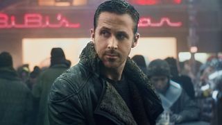 Ryan Gosling wearing his iconic jacket in a crowded city in Blade Runner 2049