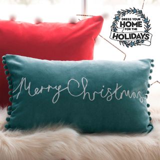 Red and green Christmas cushions on fur blanket with "Dress your home for the Holidays" stamp