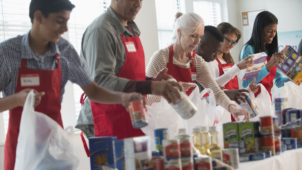 Several volunteers line up to fill bags with donated items.