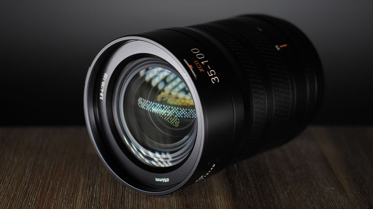 Hasselblad XCD 35-100E lens on a wooden surface in a moodily lit environment