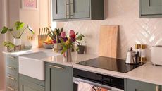 Small kitchen with white countertops and sage green cabinets