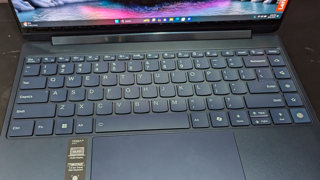 Lenovo Yoga 9i Gen 9 on a black table, with full keyboard in view