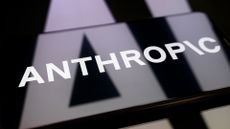 Logo of AI company Anthropic pictured on a smartphone screen placed on top of reflective surface, with company logo reflected.