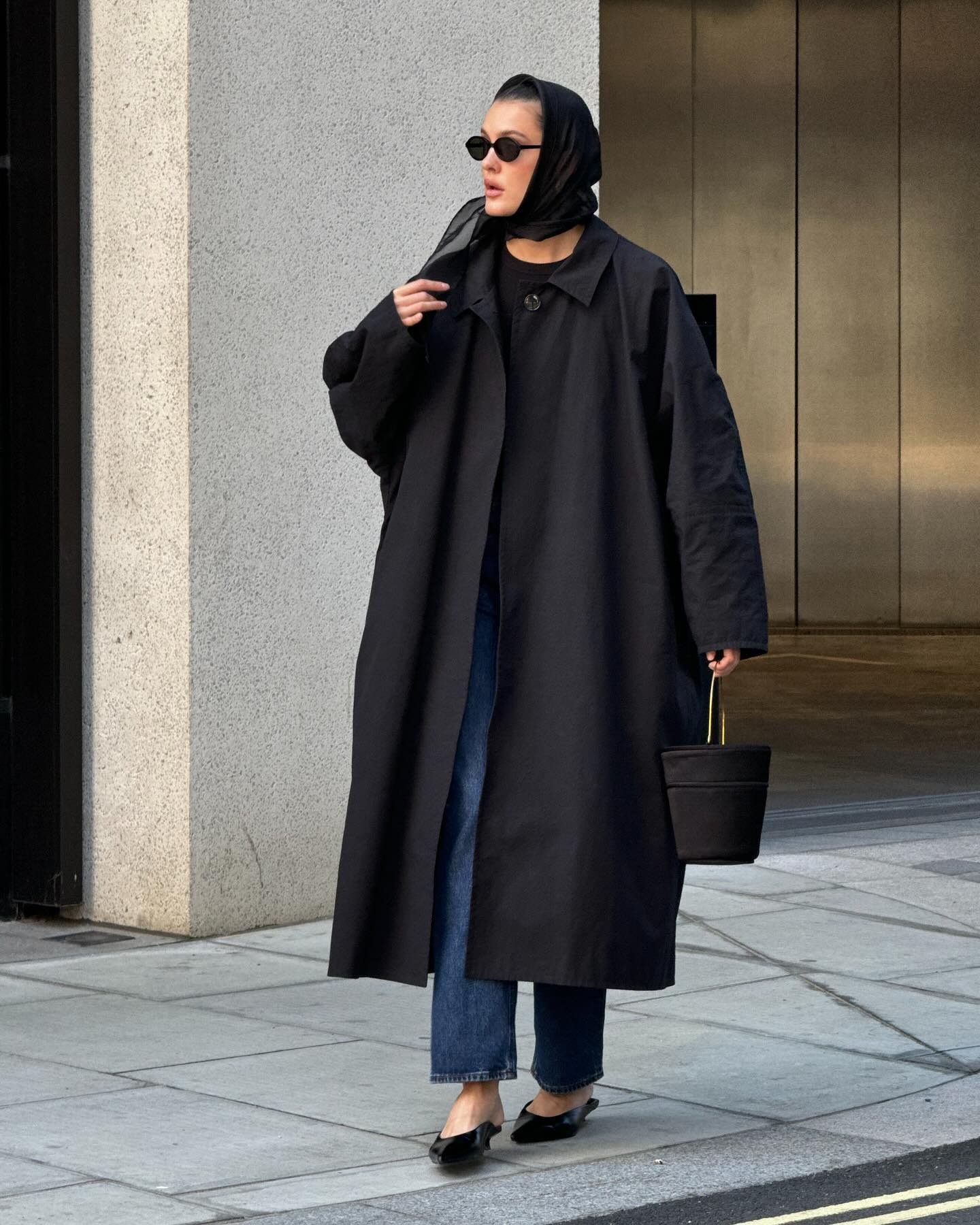 Fashion person Valeria Soba wears the black trench coat trend.