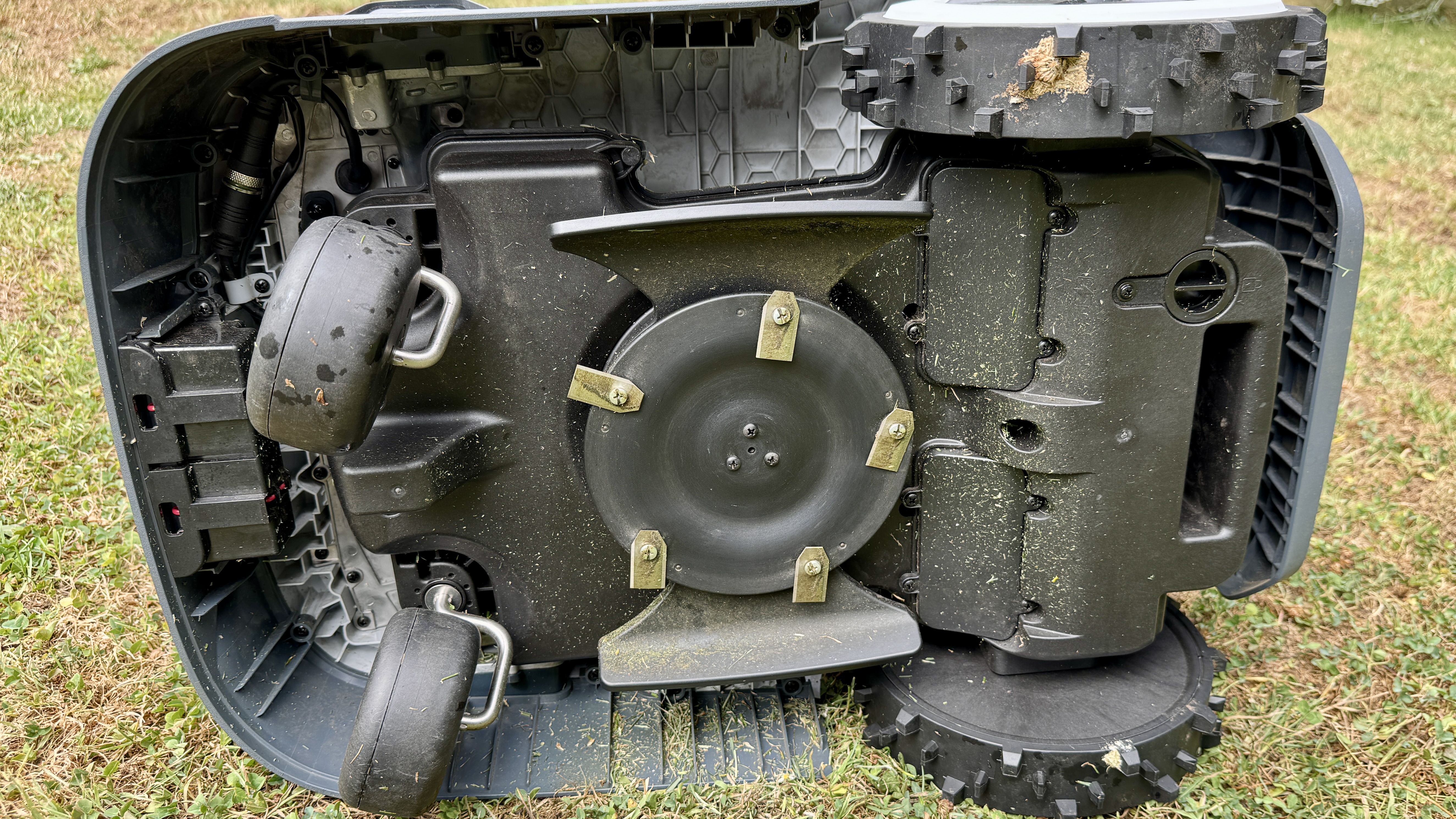 Anthbot Genie 300 robot lawn mower on its side, showing blades and wheels