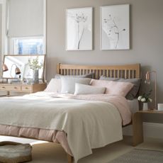 Grey and pastel bedroom with framed artwork above headboard