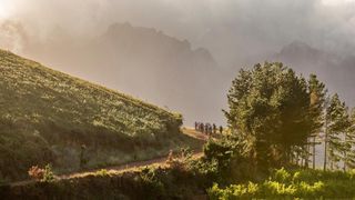Riders on the final stage of Cape Epic 2023 riding infront of mountain landscape