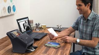 Best photo scanners: Man using Epson photo scanner to digitize photos
