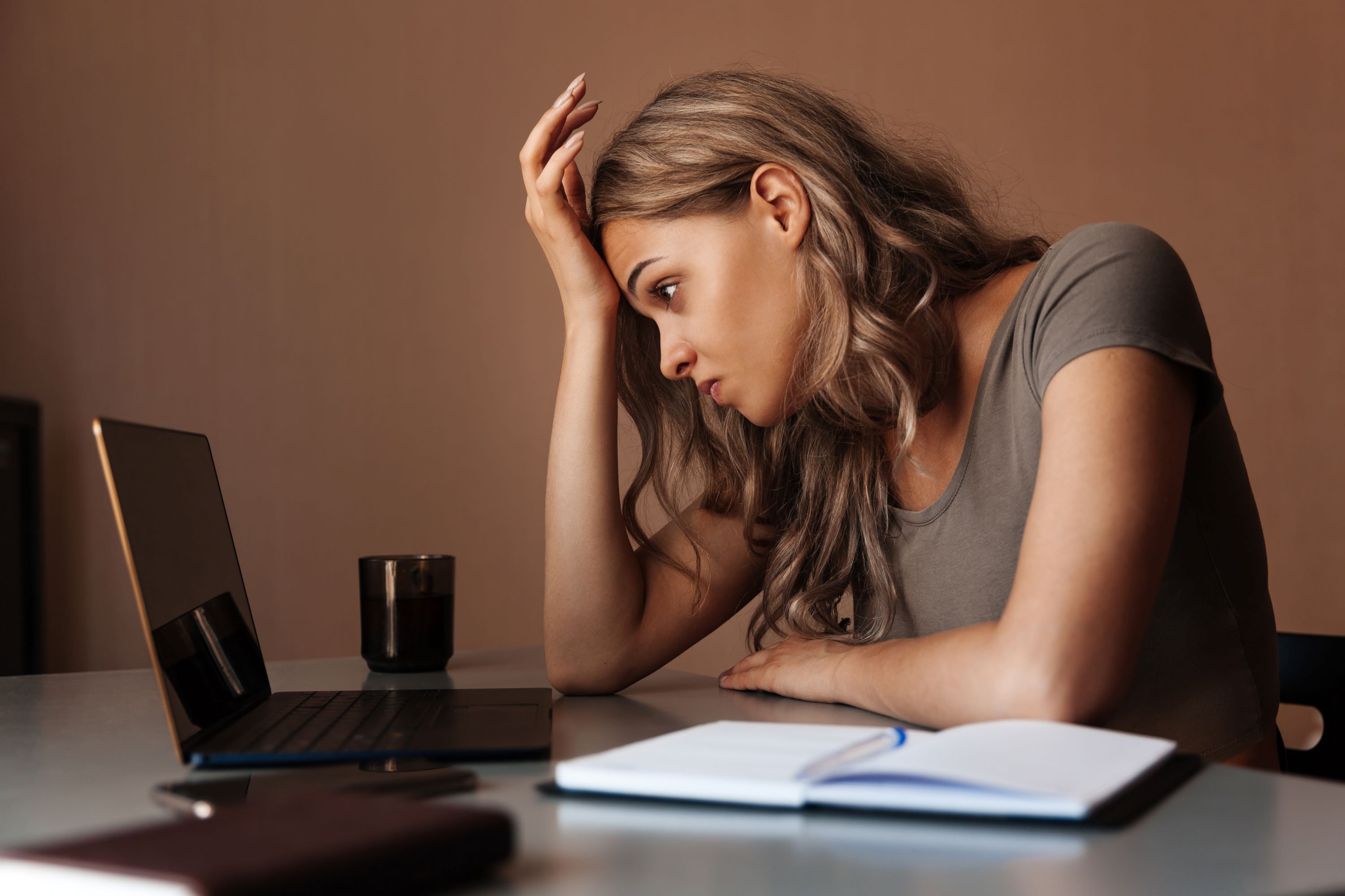 Tired woman working on laptop at home