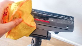 A yellow cloth cleaning a vacuum brush