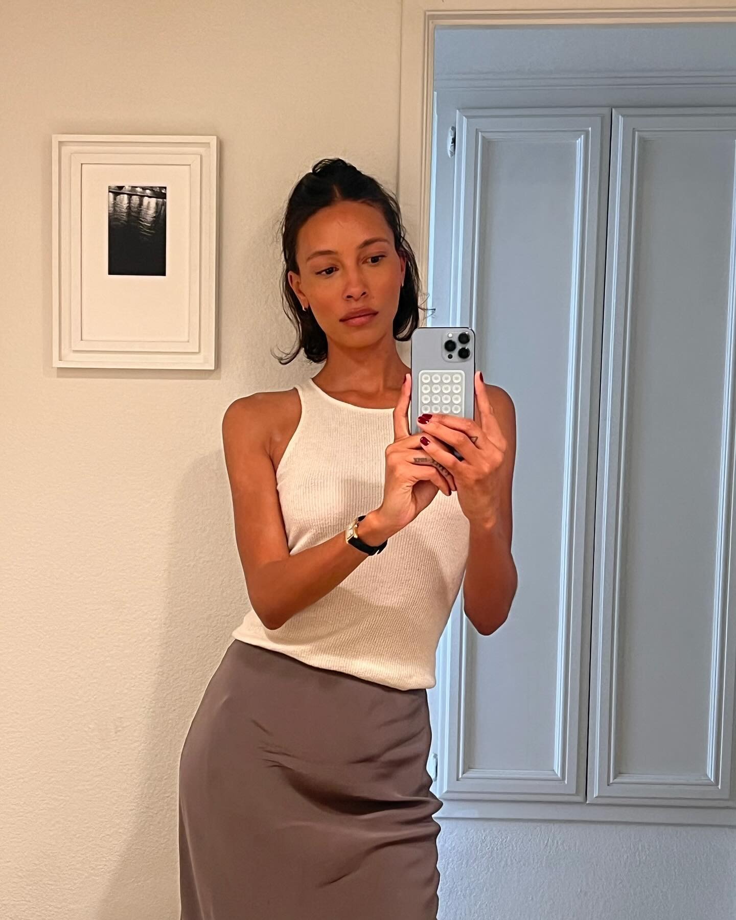A woman taking a selfie with her bob styled in a half-up, half-down hairstyle