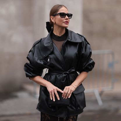 Woman wearing oversized bow, leather jacket and sunglasses with makeup using best matte foundations