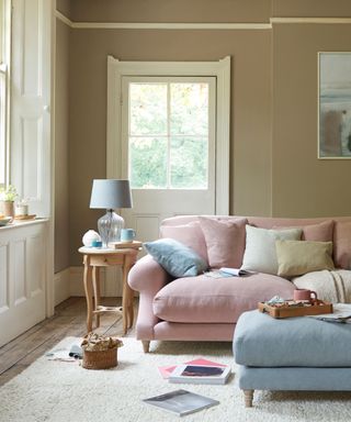 cosy living room with pink sofa, blue ottoman and side table with lamp