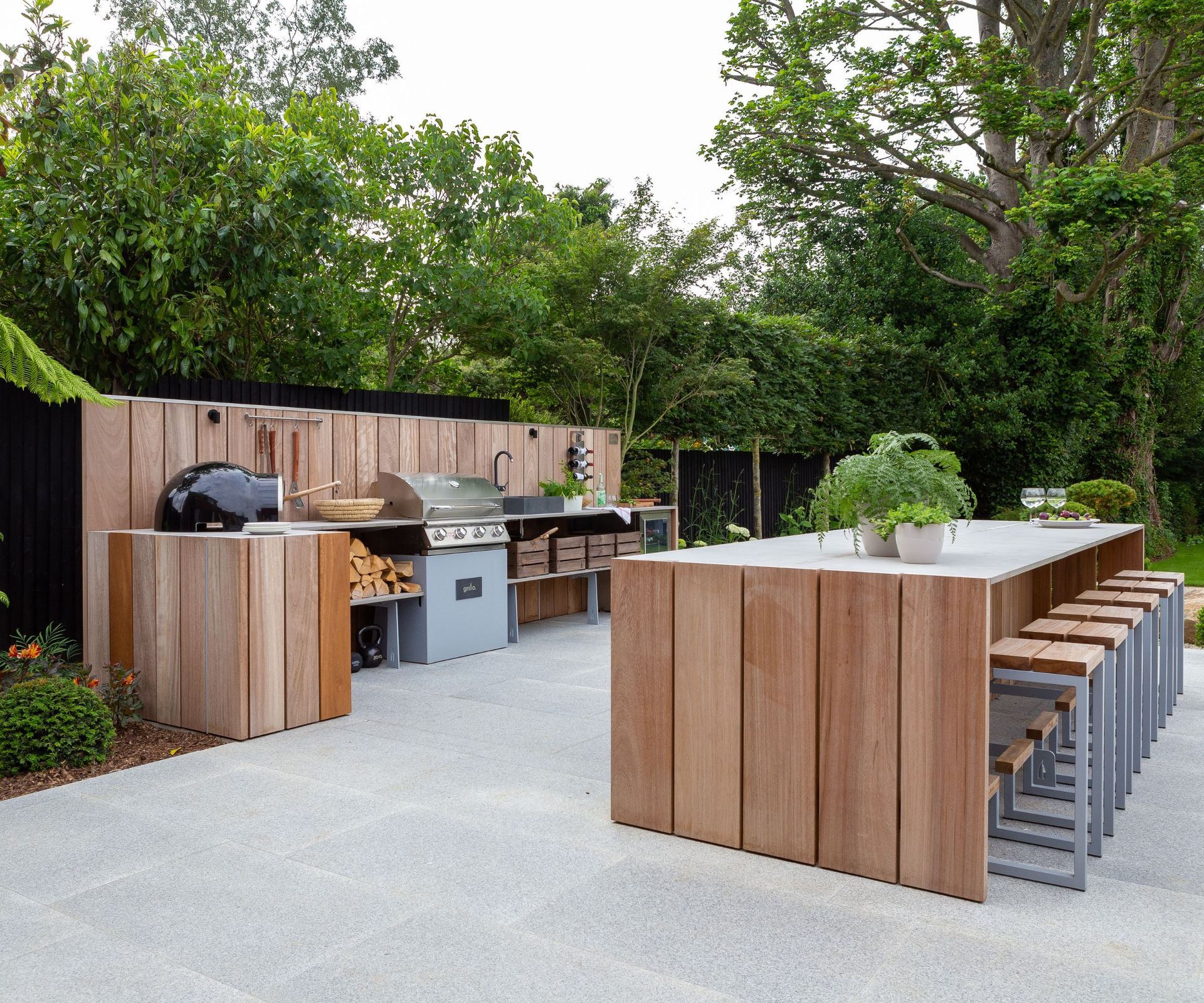An wooden outdoor kitchen with a large island