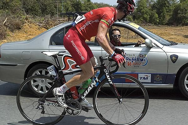 How far to go? Leader Peter McDonald checks in with his Drapac Porsche team-manager Agostino Giramondo in the team-car during his daring breakaway attempt.