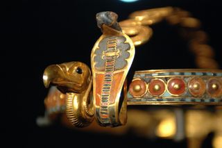 This diadem, found in Tutankhamun's tomb, has depictions of a vulture and cobra on it. It is made of gold along with glass, lapis lazuli, obsidian and malachite, among other materials.