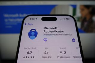 Microsoft Authenticator by Microsoft ready for download in the App Store on smartphone screen with company website in background
