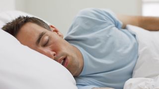 Why do men get sleepy after sex? Image shows man sleeping in bed