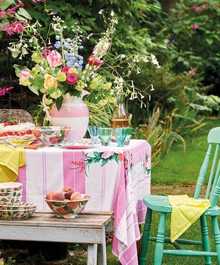 Outdoor birthday party ideas with striped tablecloth and green chair