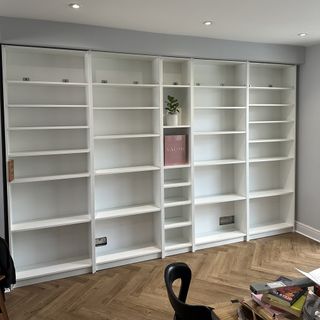 Ikea white bookshelves laid bare in a dining room.