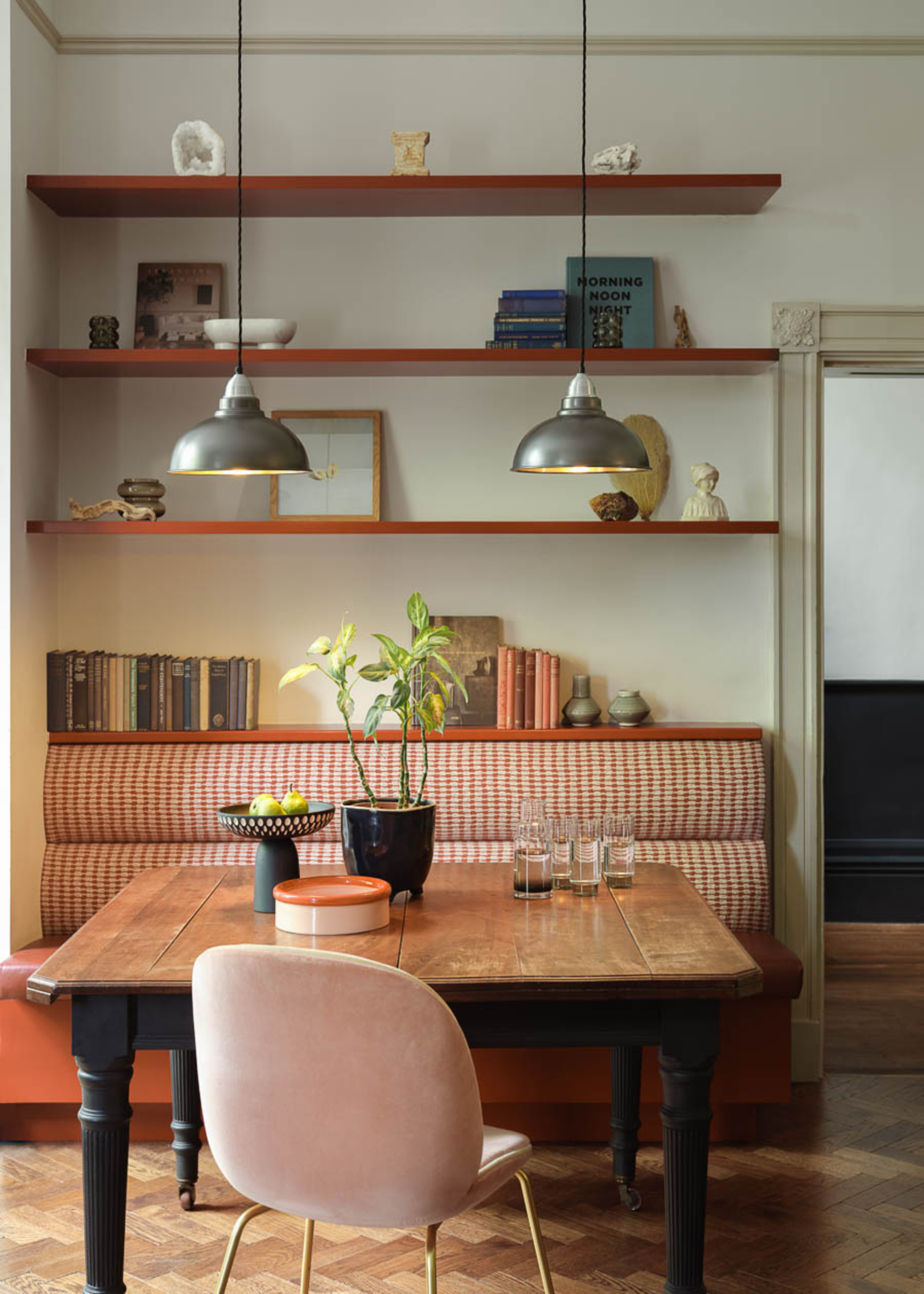 A kitchen seating area with banquette seating, a wooden table, and a chair