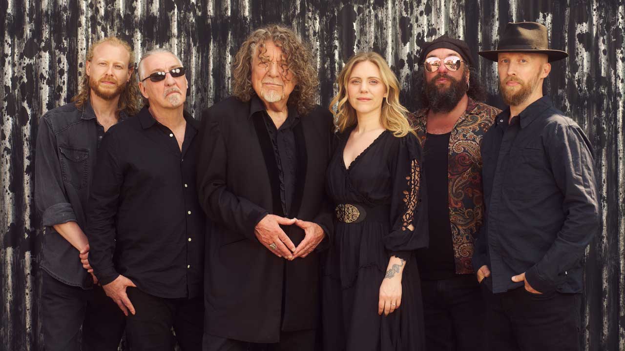 Saving Grace featuring Robert Plant and Suzy Dian standing against a corrugated fence