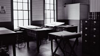 black and white image of desks by a window