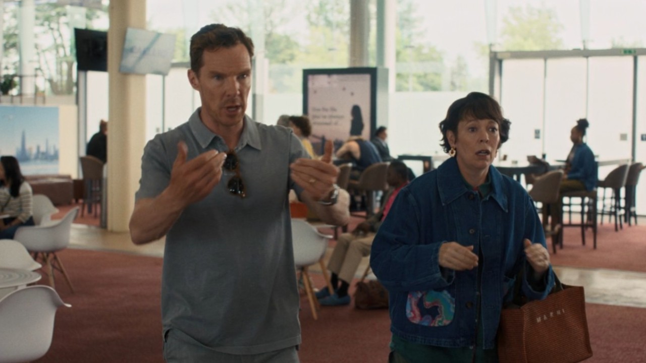 Olivia Colman and Benedict Cumberbatch standing at the airport in The Roses.