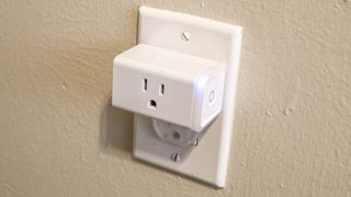 A TP-Link Kasa Smart Plug plugged into a wall outlet