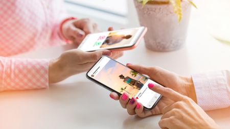 Two women using Instagram on their phones.