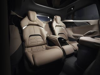 Close up image of a Ferrari Purosangue car interior, beige leather seating, door cards and centre console, white roof lining, car windows
