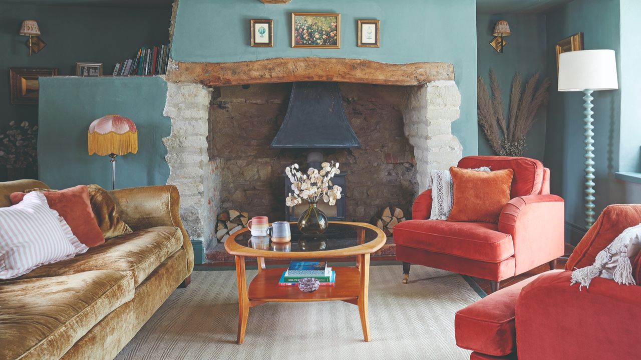 A sky blue-painted cottage-style living room with a blue bobbin floor lamp, two wall lights and a fringed table lamp