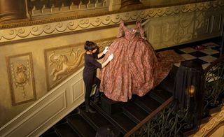 A Historic Royal Palaces conservator adjusts Vivienne Westwood's creation for 'The Enchanted Palace'.