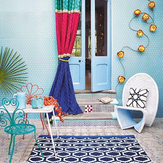 colourful geometric garden patio with wicker chair curtain and square table
