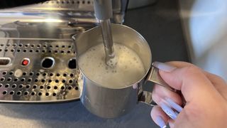 Milk being steamed and frothed for espresso coffee