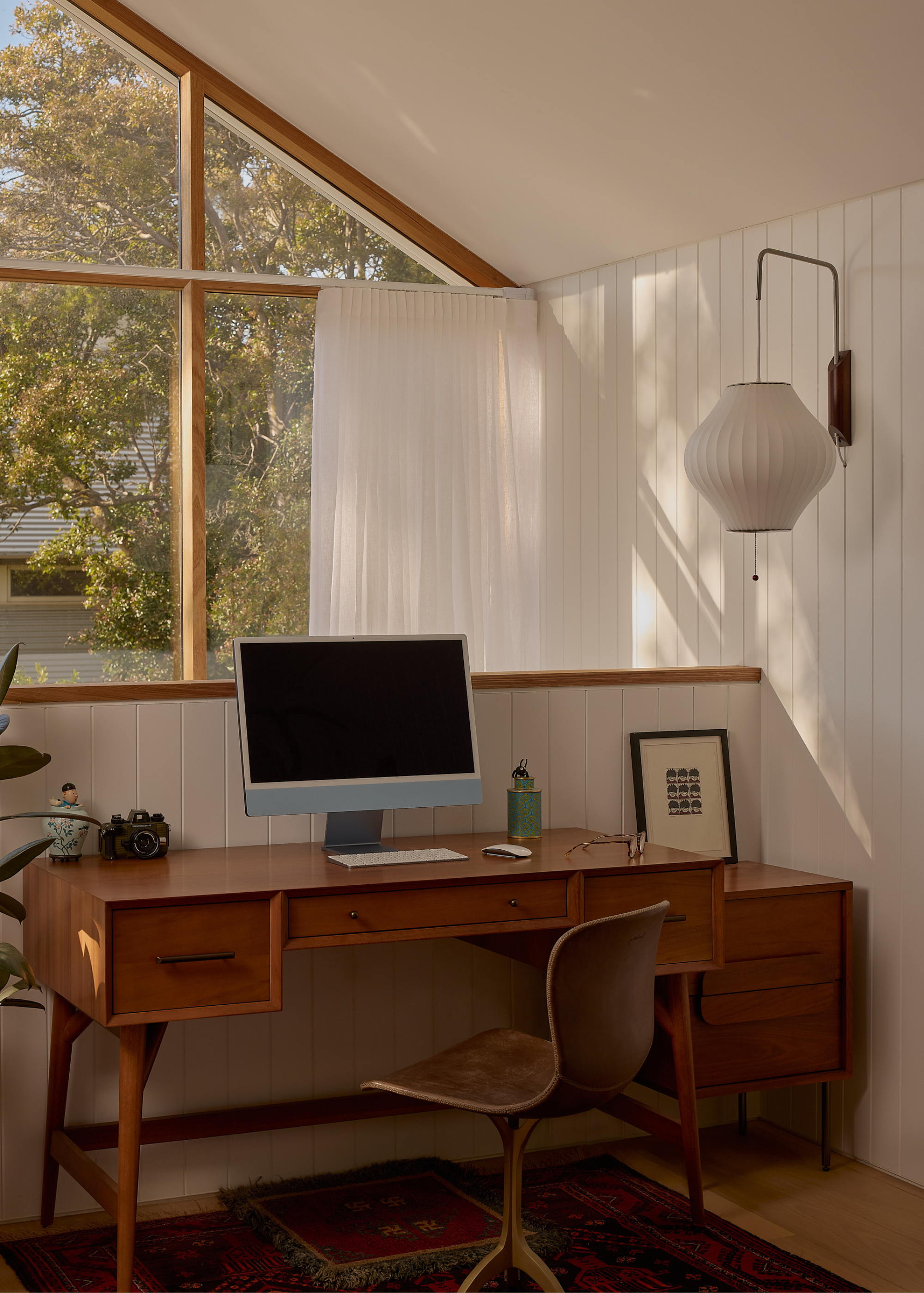 A home office with a desk, a desktop and a swivel chair