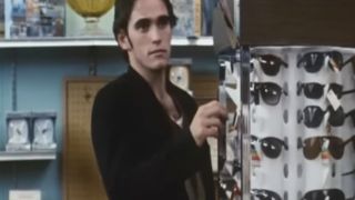 Matt Dillon looking at a sunglasses rack in a store in Drugstore Cowboy