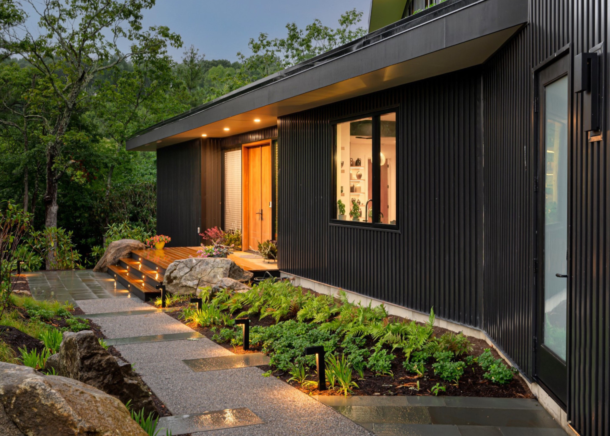 herb garden with downlighting in front yard of a modern bungalow