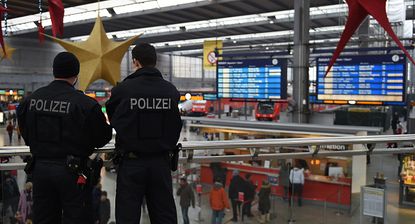 Police officers stand watch inside a Munich train station.