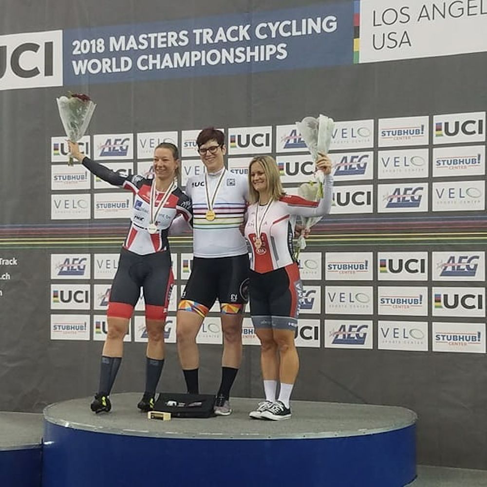 Rachel McKinnon on the Masters Worlds podium with her rainbow jersey