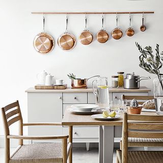 white kitchen with walled copper pans