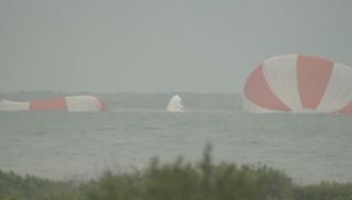 SpaceX's first Dragon crew capsule floats in the Atlantic Ocean, its parachutes nearby, after an unmanned launch abort system test from nearby Cape Canaveral Air Force Station in Florida on May 6, 2015.