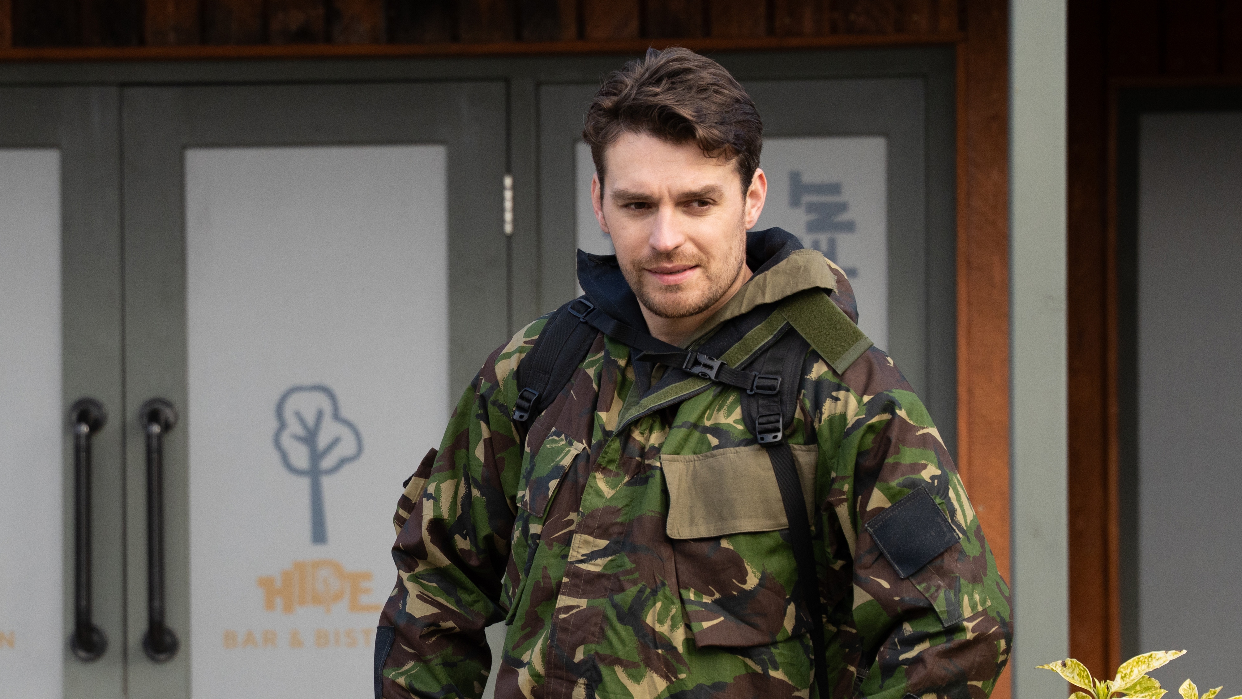 Mack looking worried while wearing a camo outfit