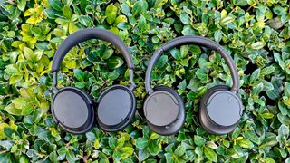 Sennheiser Accentum and Sony WH-CH720N side-by-side with green vegetation in the background