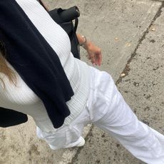 Eliza Huber wearing a white top and white linen pants.