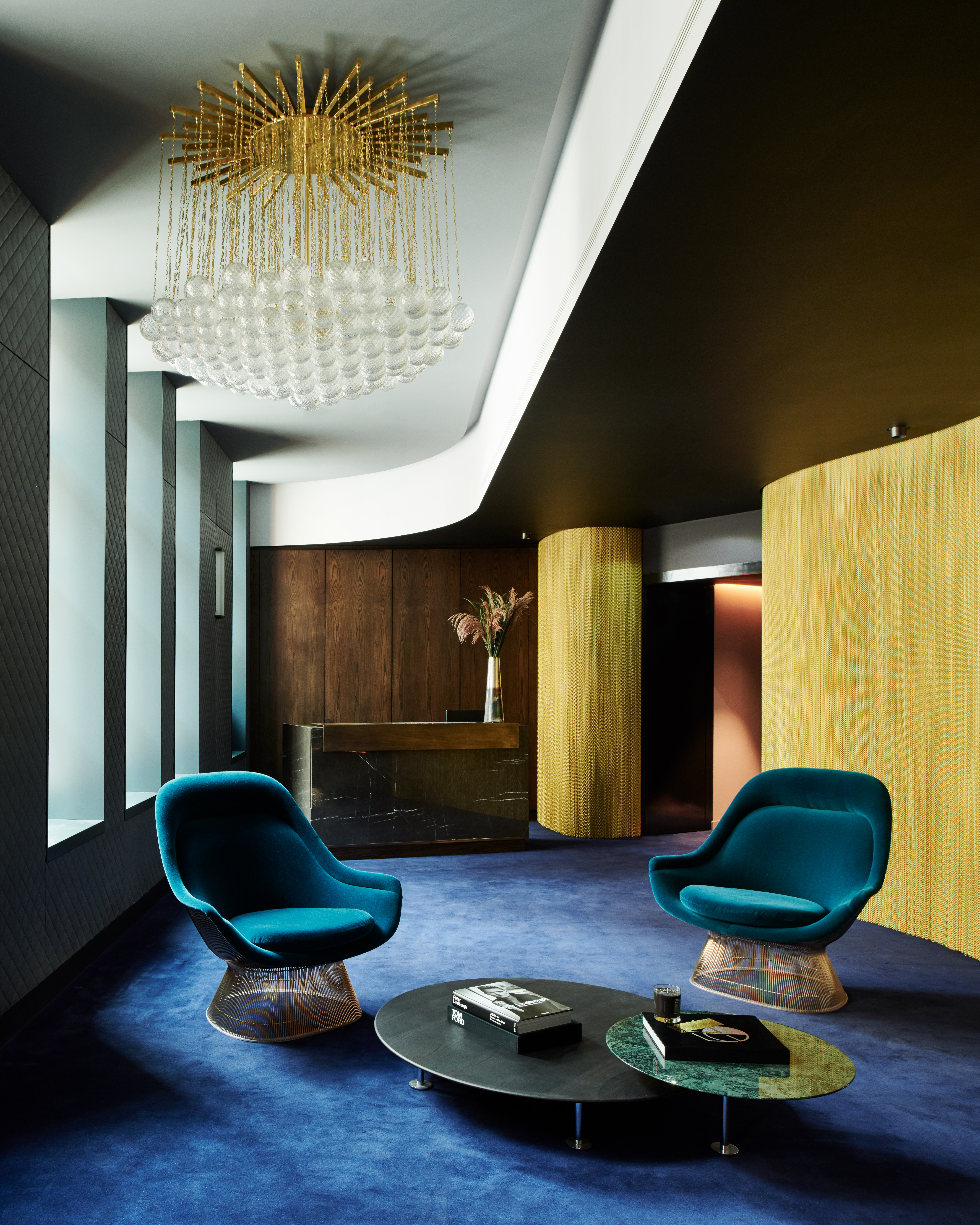 Living room with blue carpet and huge chandelier