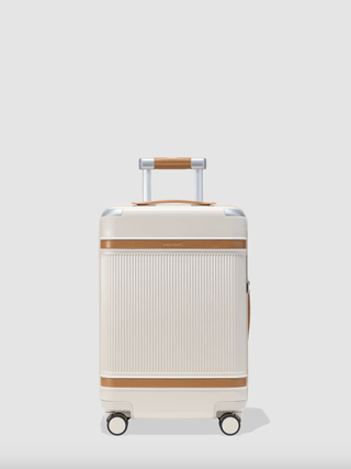 a white Paravel suitcase in front of a plain backdrop