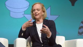 Meg Whitman sat in a white chair on a stage at a conference