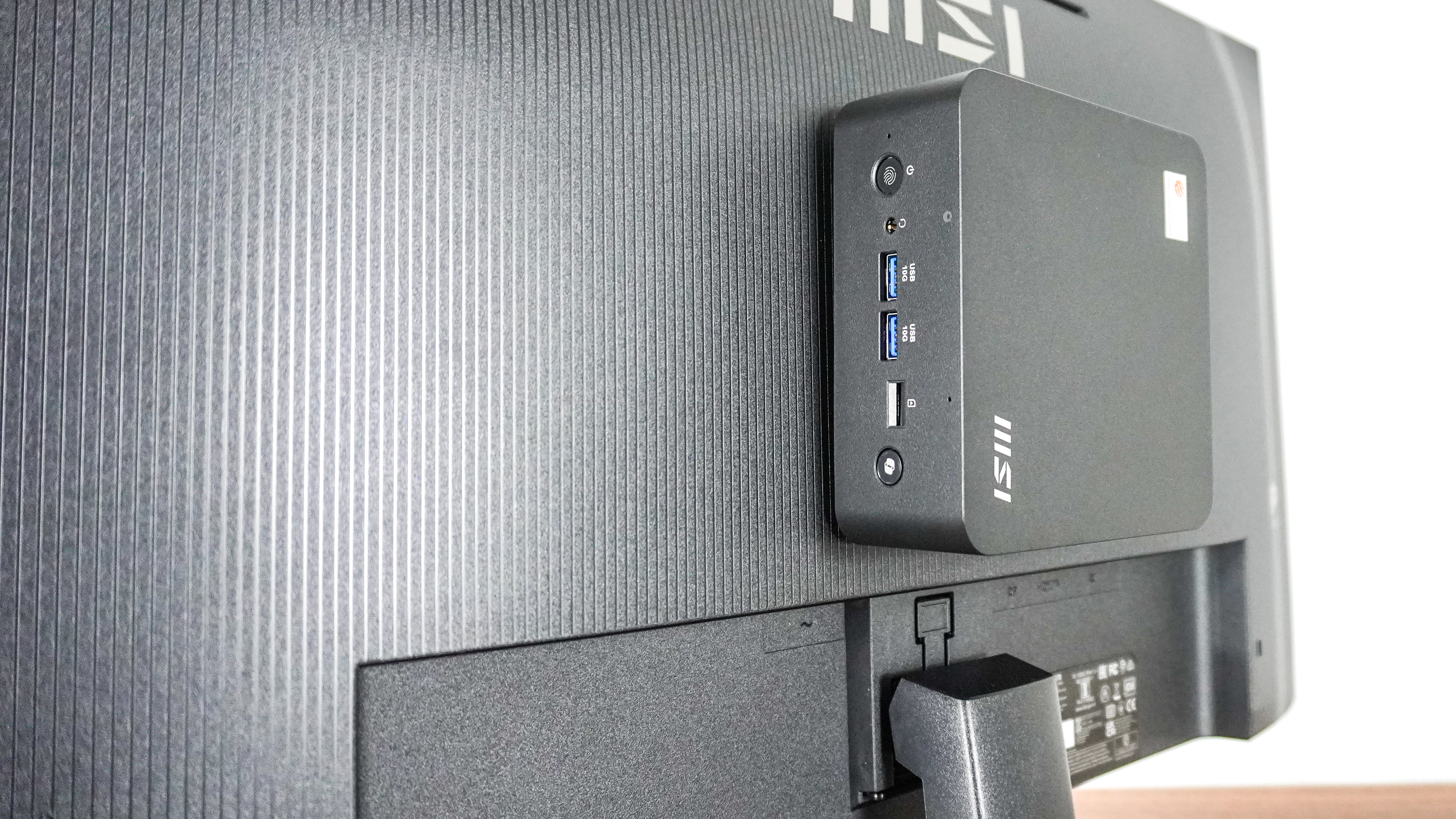 The MSI Cubi NUC AI+ 2MG mounted onto the back of a monitor