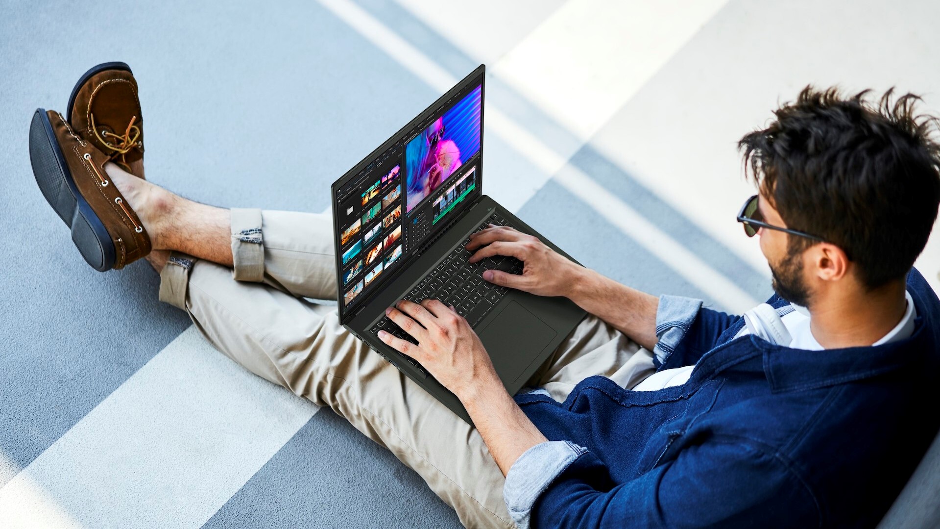 Ein Mann sitzt mit dem Acer Swift Edge 16 auf seinem Schoß.